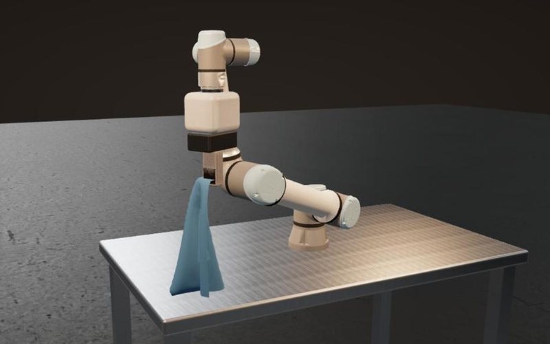Simulator render: a collaborative arm holds a blue towel by one corner; the cloth hangs and its foot rests on the table.